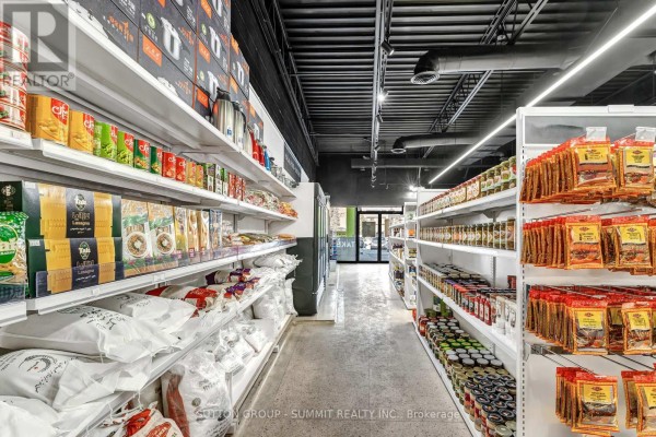 View down a market aisle with shelves stocked with bags, boxes, jars, and packaged spices. - 17 - 2500 Hurontario Street, Mississauga
