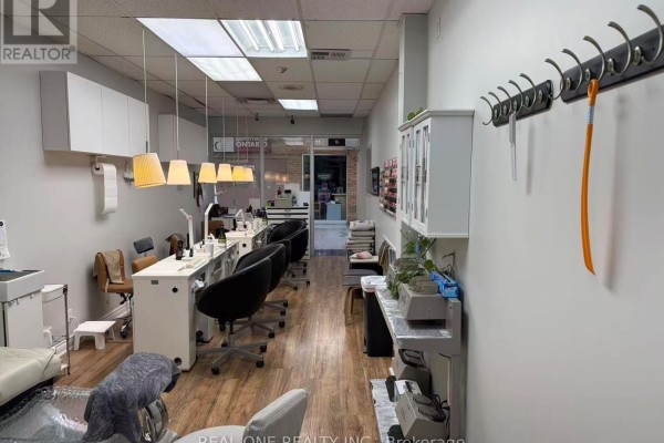 View down the length of the nail spa, showing multiple service stations and retail displays. - 17 - 3030 Don Mills Road, Toronto