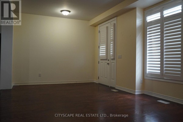 Empty room with dark hardwood floors, cream walls, white trim, and double doors. - 17 - 3045 Gladeside Avenue, Oakville
