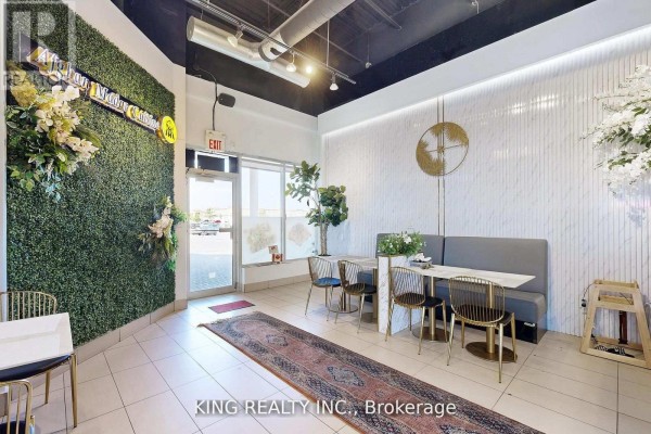 Interior dining area featuring large windows, modern decor, and tables set for guests. - 17 - 3175 Rutherford Road, Vaughan