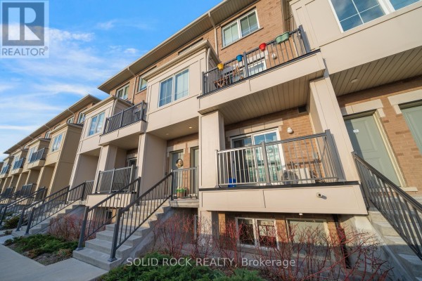 View of the townhouse complex exterior with multiple units and balconies under a blue sky. - 17 - 480 Beresford Path, Oshawa