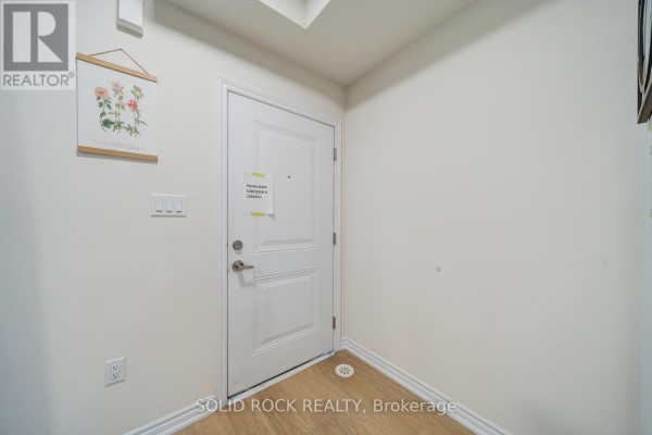 Interior hallway with a white door, light wood floor, and a framed botanical print. - 17 - 480 Beresford Path, Oshawa