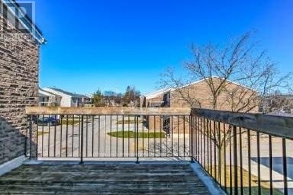Wooden deck with railing overlooking apartment buildings and parking lot - 17 - 711 Osgoode Drive London South