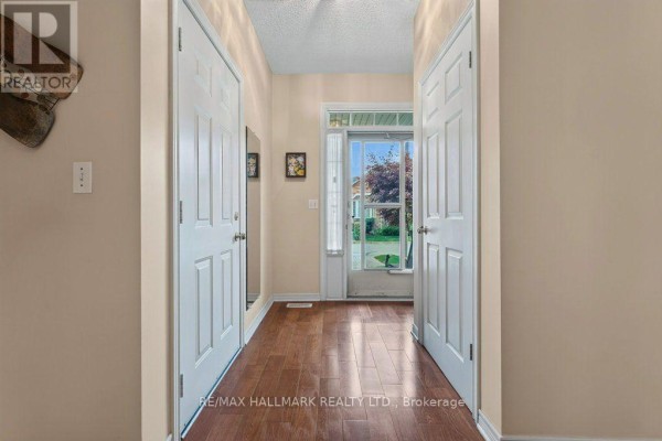 Interior hallway entrance with hardwood floors and two white doors. - 17 - 99 Linwell Road, St  Catharines