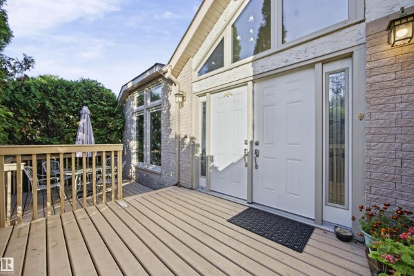 Front entrance of the house with double doors and a deck. - #17 26417 Twp Road 512, Rural Parkland County