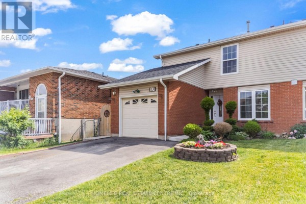 Close-up front exterior view of a brick home with a garage and landscaping. - 17 Ashford Court, Brampton