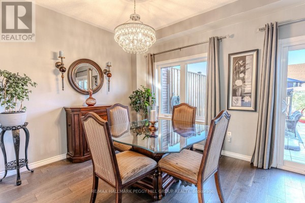 Dining room with glass table, four upholstered chairs, chandelier, and sliding glass doors to patio. - 17 Bruce Crescent, Barrie