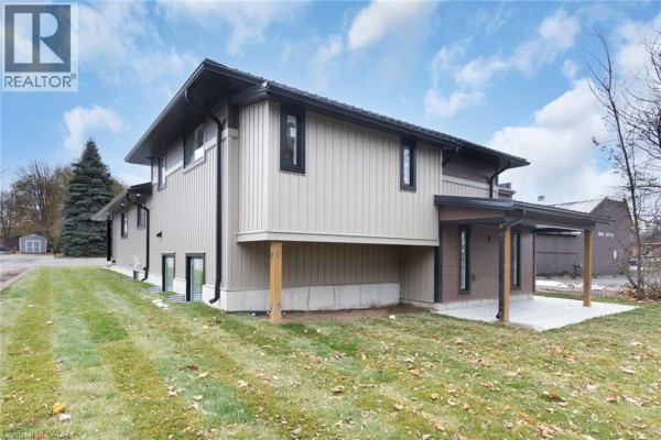 Rear exterior of a multi-level home with brown siding, concrete foundation, and covered patio area. - 17 Church Street E, Delhi