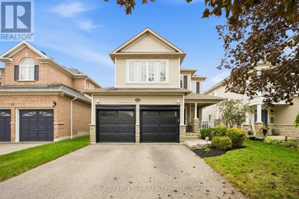 Front view of a beige two-story house with a double garage and manicured landscaping. - 17 Cody Avenue, Whitby