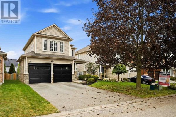 Side view of the house showcasing the double garage and driveway. - 17 Cody Avenue, Whitby