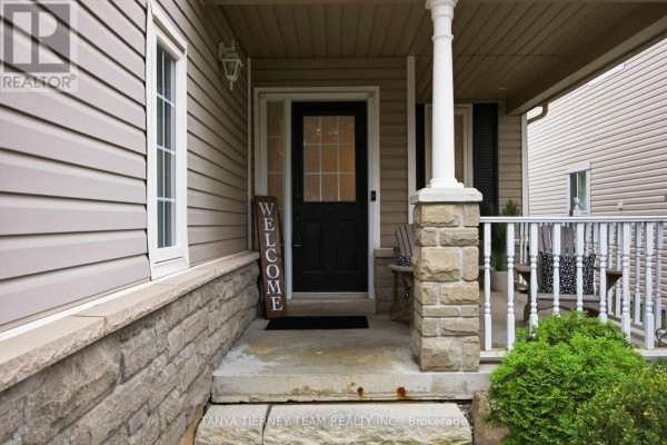 Close-up of the front entrance with a black door, stone pillars, and a welcome sign. - 17 Cody Avenue, Whitby