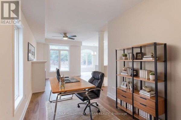 Home office with a desk, chair, bookcase, and view into a hallway and living area. - 17 Coldbrook Drive, Cavan Monaghan