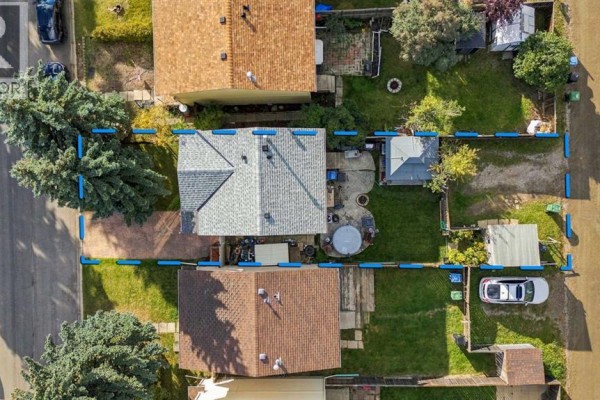 Top-down aerial view of a house lot with a driveway, backyard, shed, and neighboring properties. - 17 Erin Ridge Road Se, Calgary