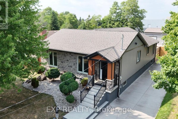 Aerial view of a single-story house with stone and vinyl siding, plus a concrete driveway. - 17 Greenfield Court, London South