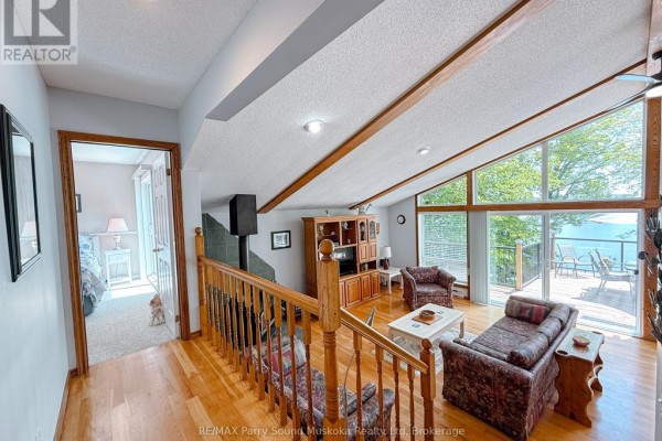 View from the landing of a living room with vaulted ceiling, leading to a bedroom. - 17 Lizzie's Lane, Mckellar