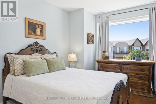 A bedroom features a wooden bed frame, dresser, and a window with a view. - 17 Matthew Court, Toronto