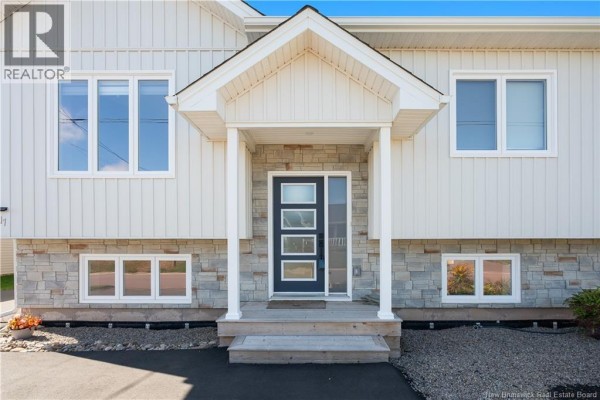 Close-up of the front entrance with a white door featuring four frosted glass panels. - 17 Robert Street, Shediac