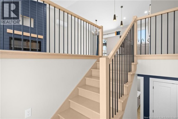 View from the staircase landing looking towards a living area with a fireplace. - 17 Robert Street, Shediac