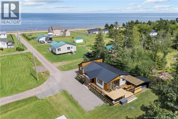 Aerial view of the house and property facing the ocean, showing surrounding homes and trees. - 17 Sandpiper, Grande Digue