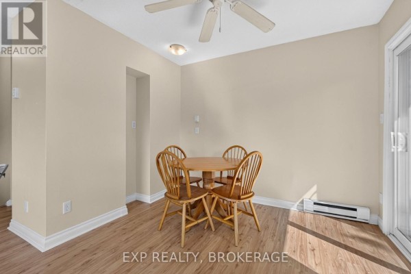 Dining area with a round wooden table, four chairs, and beige walls. - 17 Shaw Street, Kingston