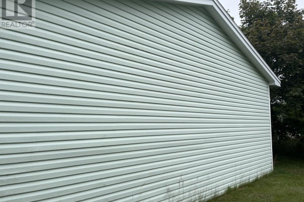Side view of a house featuring horizontal light green vinyl siding under a white soffit. - 17 View Lane, Conception Bay South