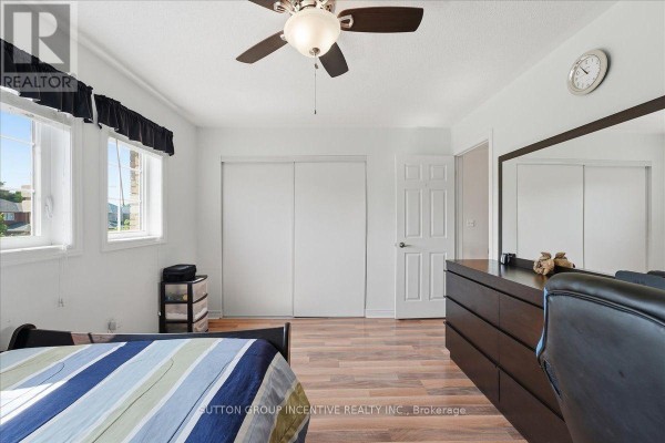 Bedroom with dresser, mirror, sliding closet doors, and ceiling fan - 17 White Crescent Barrie