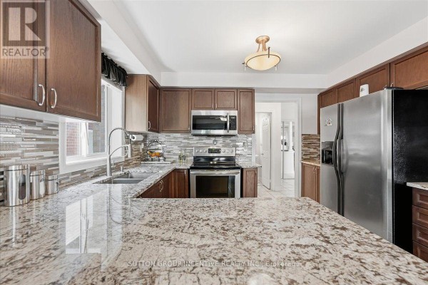Kitchen with granite countertops, stainless steel appliances, and wooden cabinets - 17 White Crescent Barrie