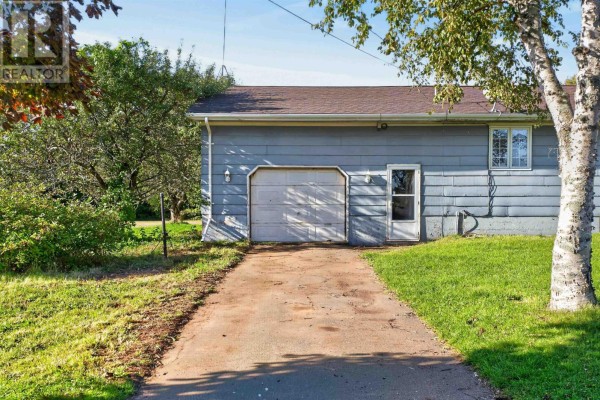 Side view of the house showing a double garage door and vinyl siding. - 170 Affleck Road, Albany