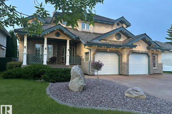 Entrance hall with high ceilings, decorative glass door, and hardwood flooring - 170 Blackburn Dr W Sw, Edmonton