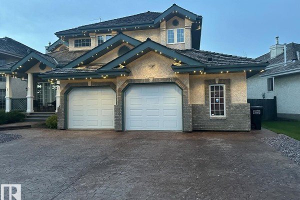 Open foyer leading to dining area, featuring a staircase and large windows - 170 Blackburn Dr W Sw, Edmonton
