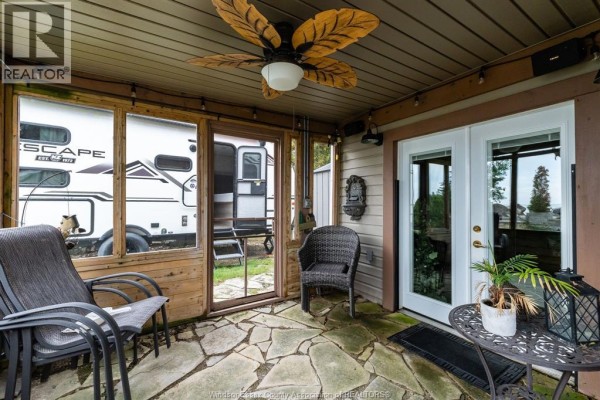 Screened-in porch with seating, a ceiling fan, and flagstone flooring. - 170 Lakeshore Road, Leamington