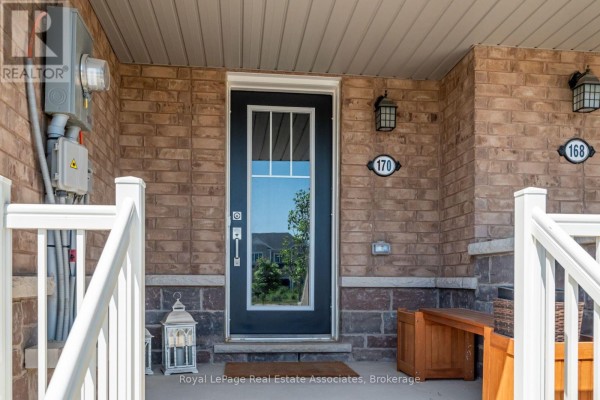 Close-up of the front door at 170 Maclachlan Avenue, with brick facade and porch light. - 170 Maclachlan Avenue, Haldimand