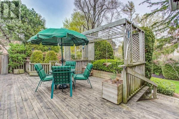 Deck with green umbrella, table, chairs, pergola, and planter box - 170 Newton Drive Toronto