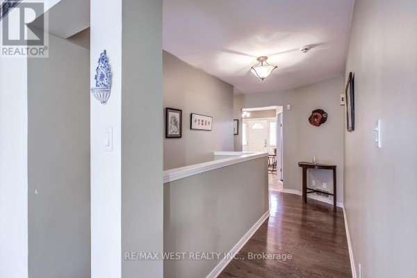 Hallway with dark wood floors, light grey walls, and a white railing. - 170 Newton Drive, Toronto