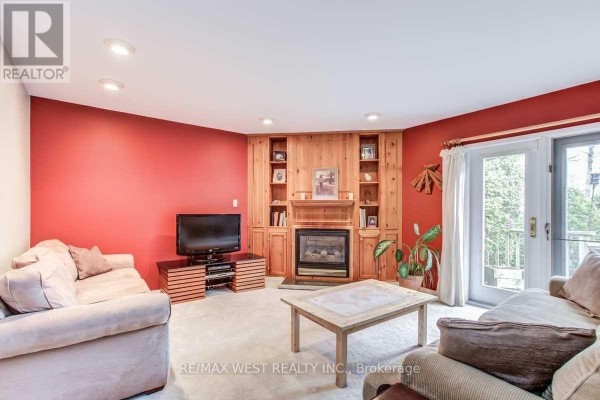 Living room with fireplace and built-in shelving - 170 Newton Drive Toronto