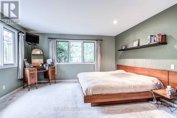 Bedroom with wooden bed, vanity, and floating shelf - 170 Newton Drive Toronto