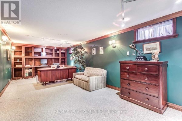 Office with built-in bookshelves, wooden desk, sofa, and dresser - 170 Newton Drive Toronto