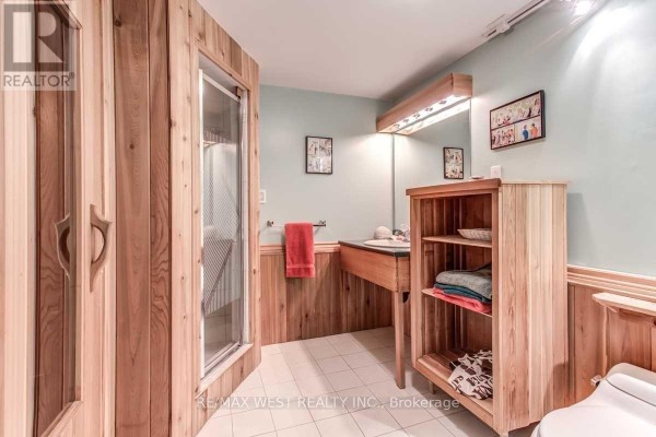Wood-paneled bathroom with glass shower, vanity, and shelves - 170 Newton Drive Toronto