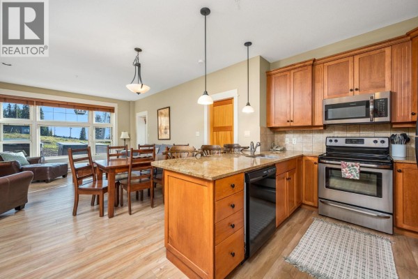 Kitchen with wooden cabinets, granite countertops, stainless steel appliances, and a dining area. - 170 Silver Lode Lane Lane Unit# 105, Silver Star
