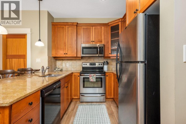 Kitchen with light wood cabinets, granite countertops, stainless steel appliances, and tiled backsplash. - 170 Silver Lode Lane Lane Unit# 105, Silver Star