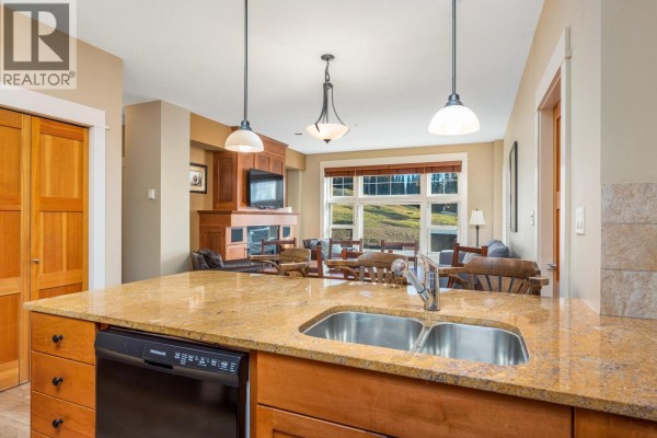 Kitchen island with a double sink overlooks the living room and dining area with a fireplace. - 170 Silver Lode Lane Lane Unit# 105, Silver Star