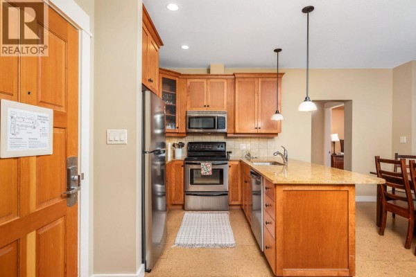 Entrance door and kitchen area with wood cabinets, granite counters, and stainless steel appliances. - 170 Silver Lode Lane Lane Unit# 304, Silver Star