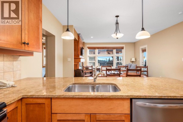 Kitchen island with double sink overlooking a dining area and living room with fireplace. - 170 Silver Lode Lane Lane Unit# 304, Silver Star
