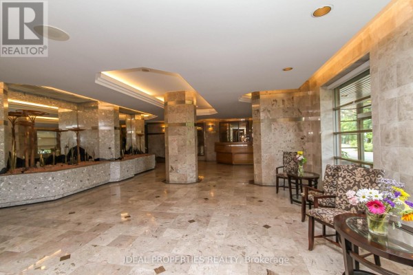 Spacious lobby with marble floors, pillars, reception desk, and seating areas. - 1701 - 2759 Carousel Crescent, Ottawa