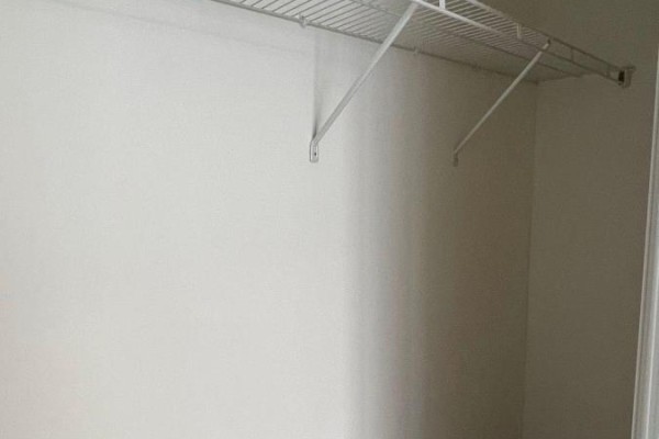 Interior of a white closet with a metal shelving unit. - 1701 - 57 St Joseph Street, Toronto