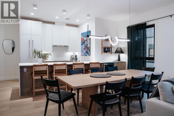 Dining space with large table, pendant lighting, and open kitchen layout - 1702 Coursier Avenue Unit# 2501, Revelstoke