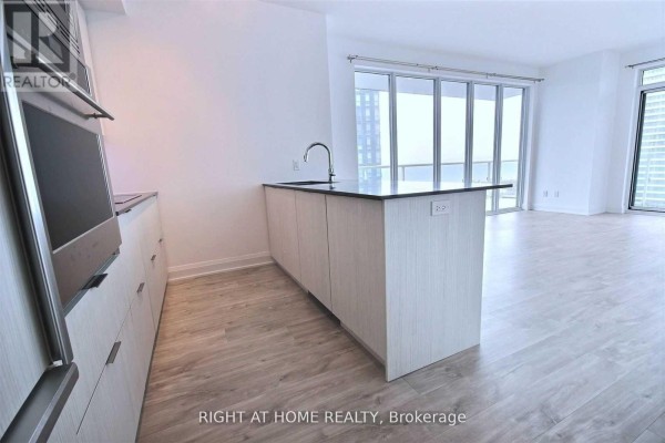 Open concept living area and kitchen with a large island and floor-to-ceiling windows. - 1703 - 56 Annie Craig Drive, Toronto