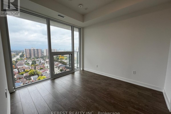 Bedroom with large windows overlooking the city, white walls, and dark wood floors. - 1704 - 209 Steeles Avenue W, Brampton