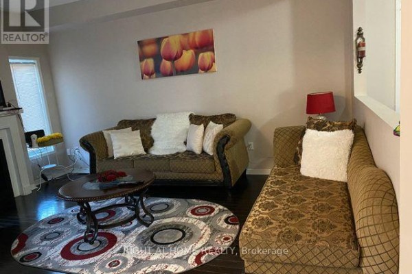 Living area with a sofa, chaise lounge, coffee table, and fireplace. - 1704 - 530 Lolita Gardens, Mississauga