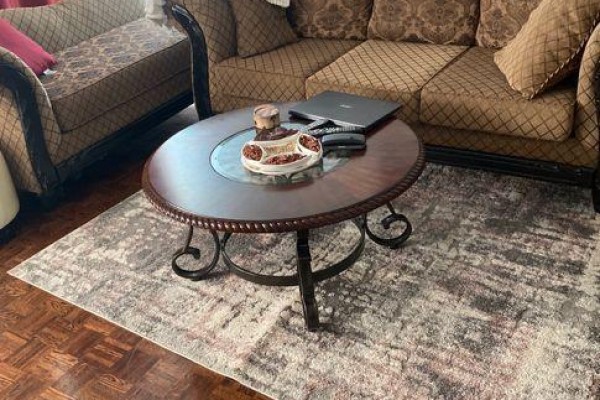 Close-up of a round coffee table on a rug in front of a sofa. - 1704 - 530 Lolita Gardens, Mississauga
